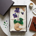 Handmade 3D purple violet stained glass flower casting vibrant colored shadows, available with a custom engraved wooden base or standalone for vase display, perfect for personalized Mother's Day gift and February birth flower desk decor.