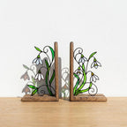 Handmade stained glass white snowdrop flower bookends with delicate wirework on solid wood bases, beautiful january birth flower spring shelf decor and book lover gift.