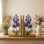 Handmade stained glass purple larkspur flower bookends on premium wood bases casting colorful shadows, beautiful July birth flower botanical shelf decor.