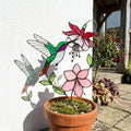 Handmade stained glass hummingbird and pink fuchsia flower plant stake decor in a potted plant, beautiful spring suncatcher and Mother's Day gift.