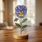 Handcrafted flat stained glass birth month flowers standing on personalized wooden bases, casting colorful light reflections. Perfect Mother's Day or birthday gift.