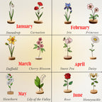 Handcrafted flat stained glass birth month flowers standing on personalized wooden bases, casting colorful light reflections. Perfect Mother's Day or birthday gift.