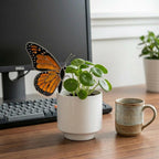 Handmade stained glass monarch butterfly plant stake displayed in a green ceramic planter