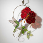 Handmade hummingbird and red hibiscus flower stained glass suncatcher casting vibrant colored shadows, perfect tropical botanical decor and memorial gift for mom.