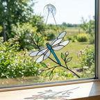 Handcrafted iridescent stained glass dragonfly suncatcher on a branch casting colored shadows, perfect memorial or Mother's Day window decor gift.