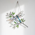 Handcrafted iridescent stained glass dragonfly suncatcher on a branch casting colored shadows, perfect memorial or Mother's Day window decor gift.