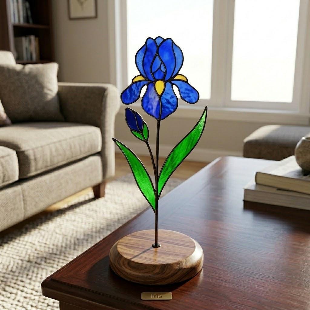 Handcrafted 3D stained glass blue iris flower standing on a wooden base with a brass nameplate, casting colored shadows, perfect Mother's Day desk decor gift.